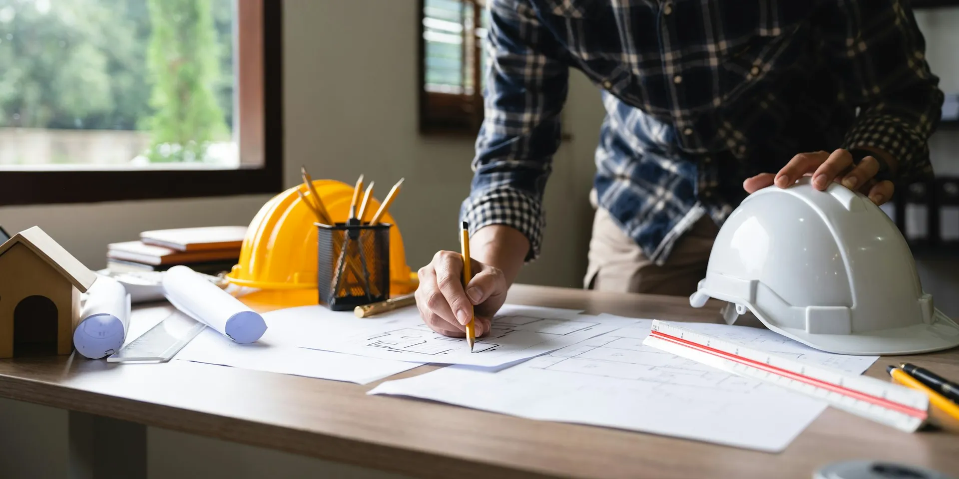 Contractor reviewing construction plans at a work table